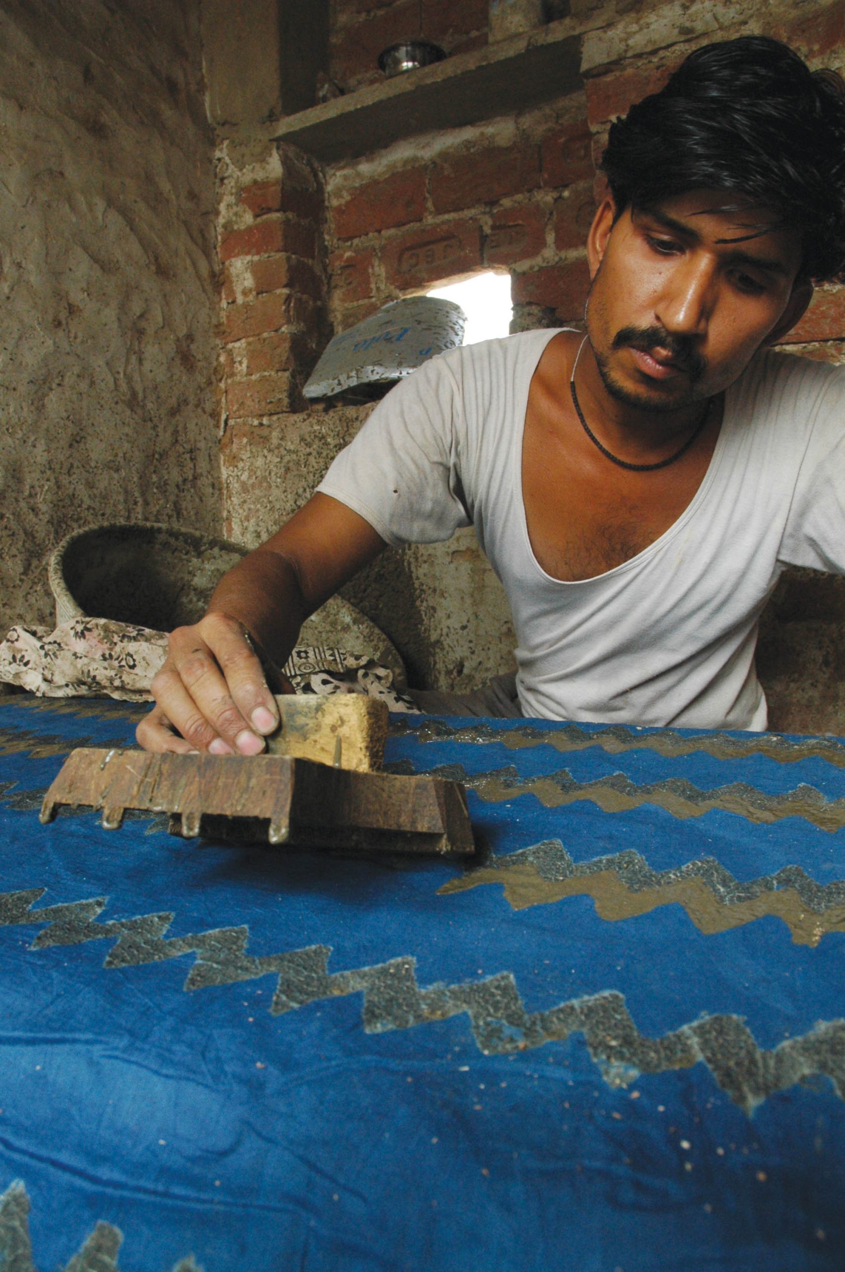 A carver finishes a lotus block in the Chippa family workshop.